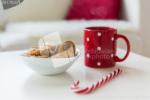 Image of close up of oat cookies, sugar cane candy and cup