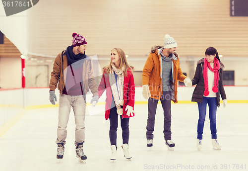 Image of happy friends on skating rink