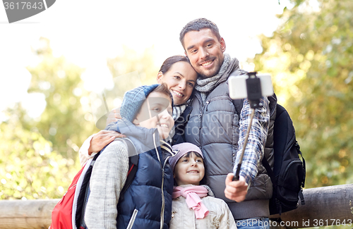 Image of happy family with smartphone selfie stick in woods