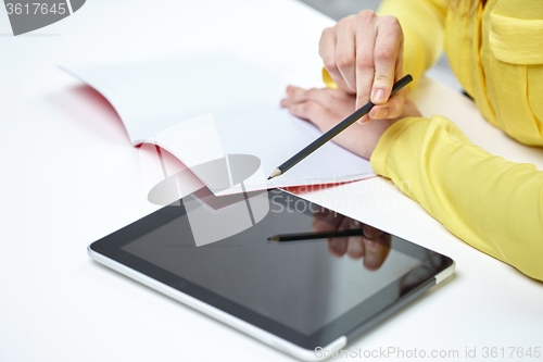 Image of close up of woman with tablet pc and notebook