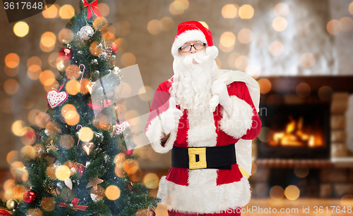 Image of santa claus with bag showing thumbs up at home