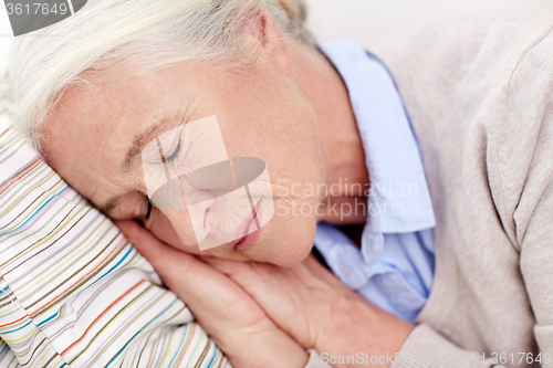 Image of happy senior woman sleeping on pillow at home