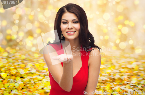 Image of beautiful woman in red dress over golden lights