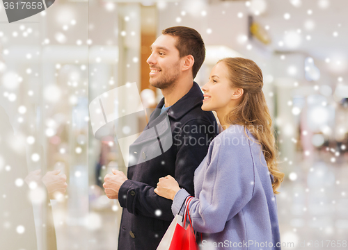 Image of happy young couple with shopping bags in mall