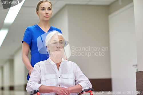 Image of nurse with senior woman in wheelchair at hospital