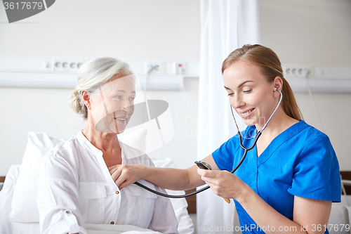 Image of nurse with stethoscope and senior woman at clinic