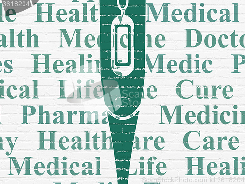 Image of Medicine concept: Thermometer on wall background