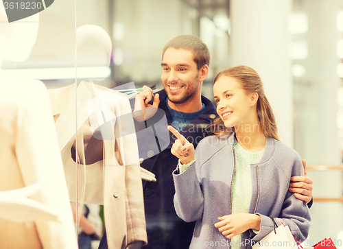 Image of happy young couple with shopping bags in mall