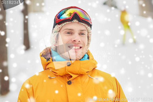 Image of happy young man in ski goggles outdoors