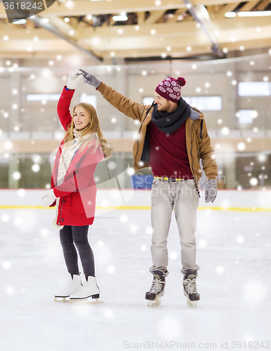 Image of happy couple holding hands on skating rink