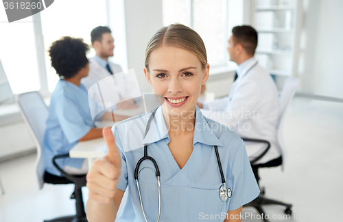 Image of happy doctor over group of medics at hospital