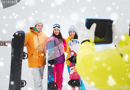 Image of happy friends with snowboards and tablet pc