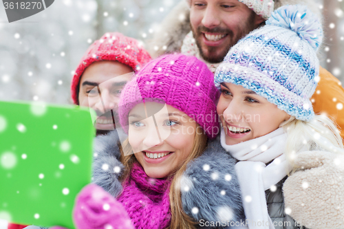 Image of smiling friends with tablet pc in winter forest