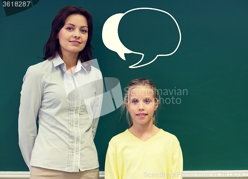 Image of little school girl with teacher at blackboard