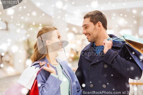 Image of happy young couple with shopping bags in mall