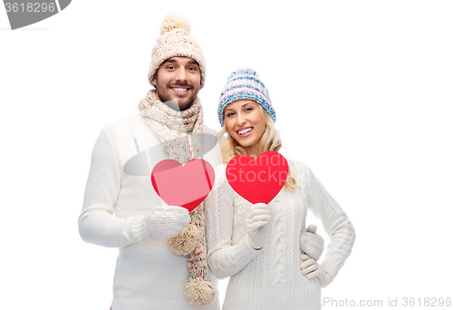 Image of smiling couple in winter clothes with red hearts