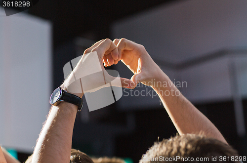 Image of close up of fan hands showing heart at concert