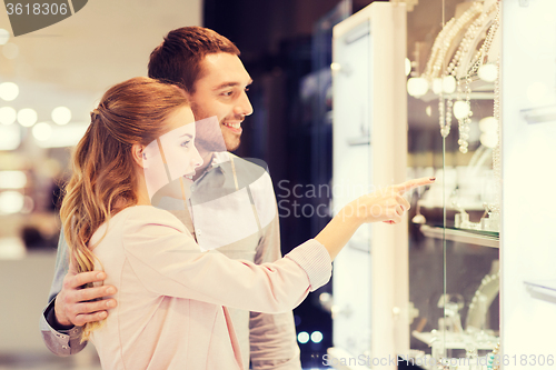 Image of couple looking to shopping window at jewelry store