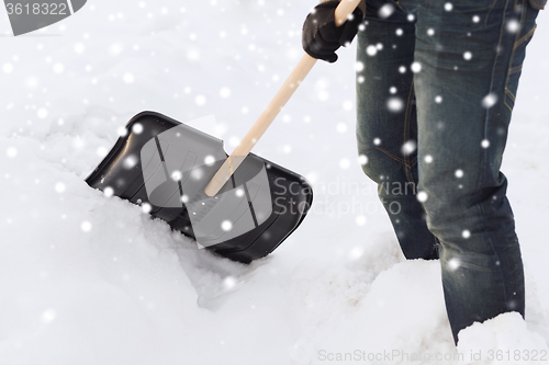 Image of closeup of man digging snow with shovel