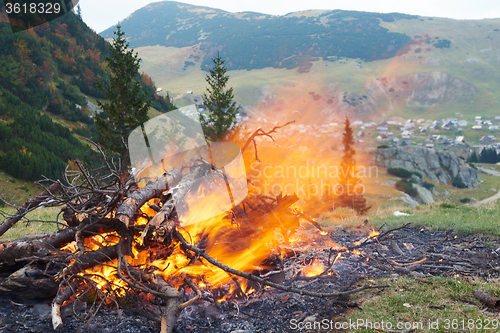 Image of hiking man prepare tasty sausages on campfire