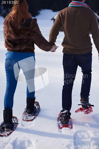 Image of couple having fun and walking in snow shoes