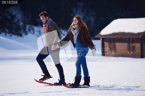 Image of couple having fun and walking in snow shoes