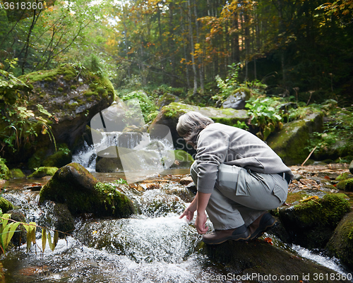 Image of man drinking fresh water from spring