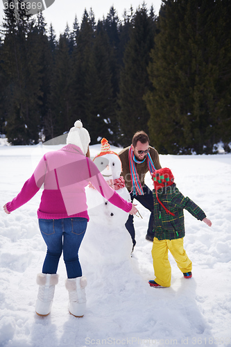 Image of happy family building snowman