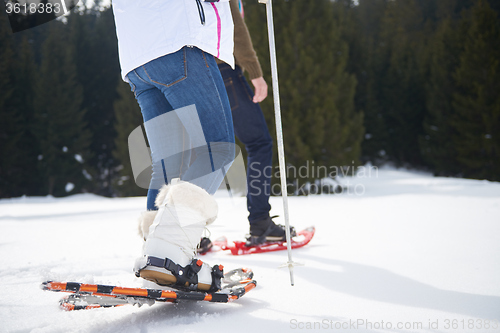 Image of couple having fun and walking in snow shoes