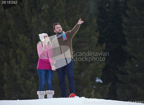 Image of couple having fun and walking in snow shoes