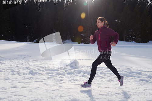 Image of yougn woman jogging outdoor on snow in forest