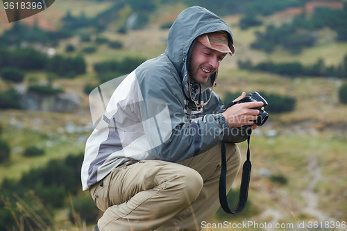 Image of hiking man prepare tasty sausages on campfire