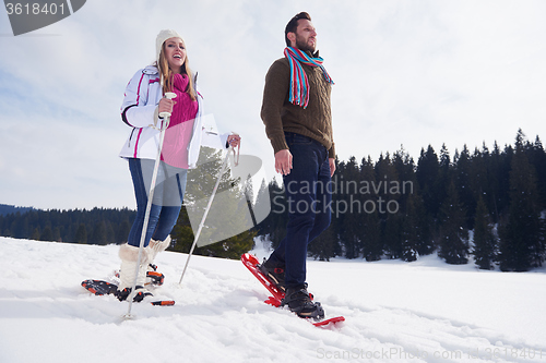 Image of couple having fun and walking in snow shoes