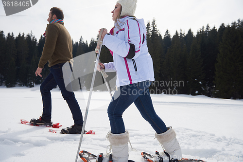 Image of couple having fun and walking in snow shoes