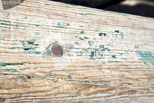 Image of metal nail dirty stripped paint in green