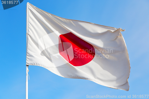 Image of japanb waving flag in the blue sky 