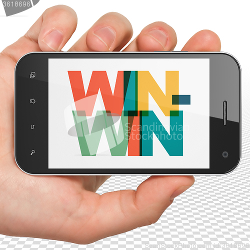 Image of Finance concept: Hand Holding Smartphone with Win-Win on  display