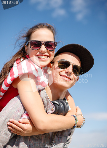 Image of smiling teenagers in sunglasses having fun outside