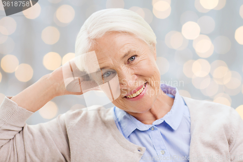 Image of happy senior woman face over lights background