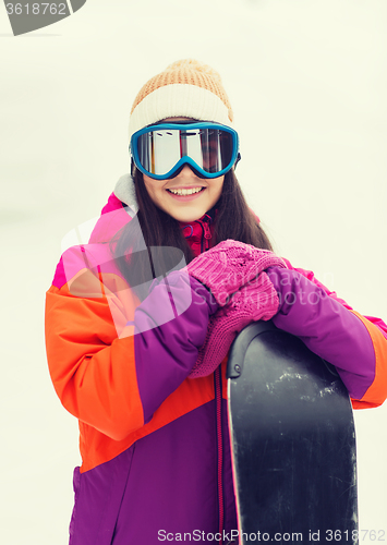 Image of happy young woman with snowboard outdoors