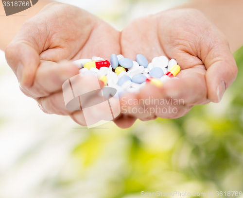 Image of close up of senior woman hands with pills