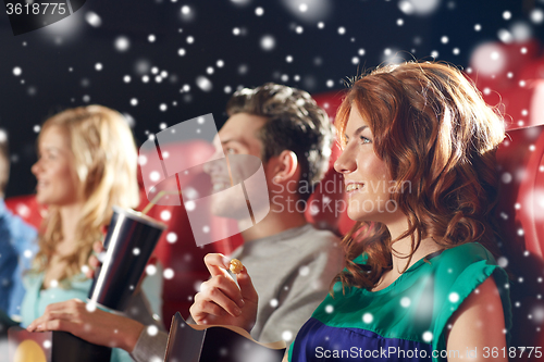 Image of happy friends with popcorn and drinks in cinema