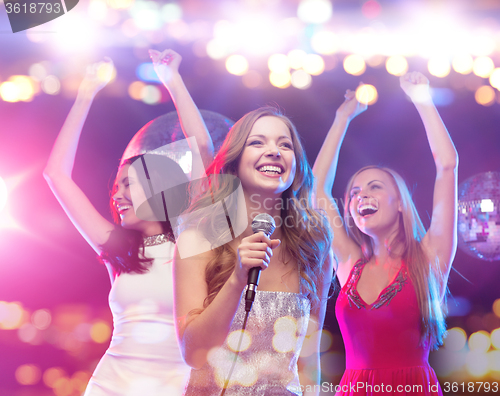 Image of happy women singing karaoke and dancing