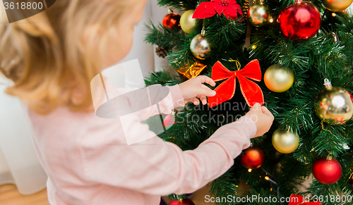 Image of close up of little girl decorating christmas tree