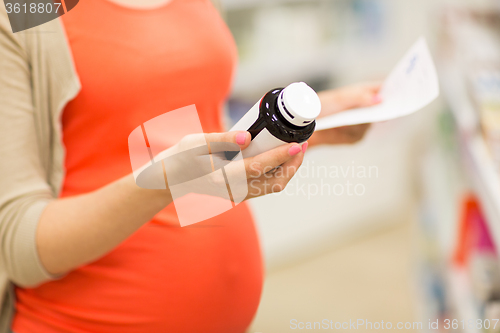 Image of pregnant woman with medication jar at pharmacy