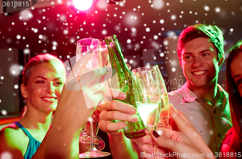 Image of smiling friends with glasses of champagne in club