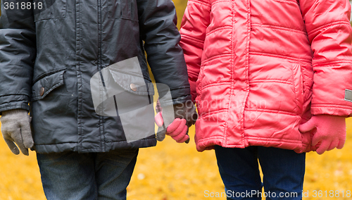 Image of close up of girl and boy holding hands outdoors