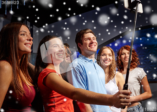 Image of friends with smartphone taking selfie in club