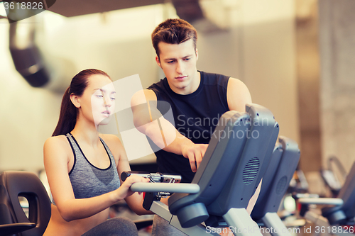 Image of woman with trainer on exercise bike in gym