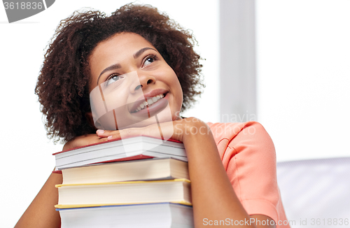 Image of happy african student girl with books at home